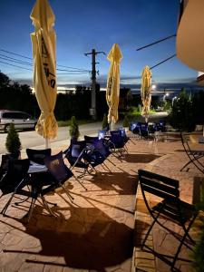 a group of chairs and umbrellas on a patio at Motel California in Mărtineşti