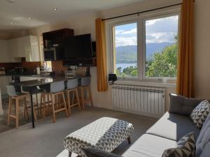 a living room with a kitchen and a large window at Number 6 in Fort William