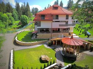 a building with a gazebo in the middle of a yard at Pensiunea Favorit Ferice in Borsec