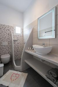 een badkamer met een wastafel, een toilet en een spiegel bij Aristeides - Moscha Apartments in Platis Yialos Sifnos