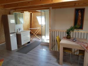 a kitchen and dining room with a table and a refrigerator at De Loft in Zuid-Scharwoude