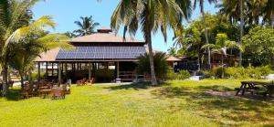 a building with a group of tables and palm trees at Ko-Sa Beach Resort in Ampeni