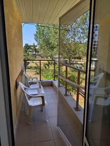 a balcony with white chairs and a view of a field at Elixirum in Jupiter