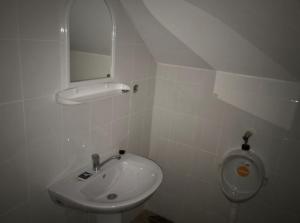 a white bathroom with a sink and a urinal at Motel California in Mărtineşti