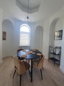 a dining room with a table and chairs and a window at Monte Gdynia Apartament in Gdynia
