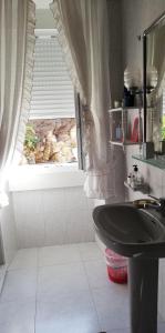 ein Bad mit einem Waschbecken und einem Fenster in der Unterkunft Rakel in Muros