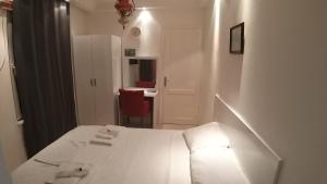 a white room with a bed and a red chair at Görkemli Hotel in Istanbul +46 photos