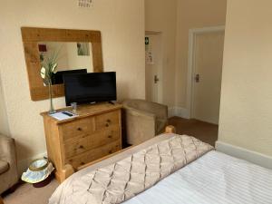 a bedroom with a bed and a television on a dresser at Broughton Craggs Hotel in Cockermouth