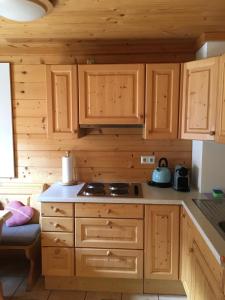 a kitchen with wooden cabinets and a stove at Berg Chalet 303 in Turracher Hohe