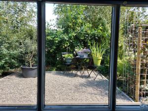 una finestra con vista su un giardino con piante in vaso di Holiday Home Canal View ad Alkmaar