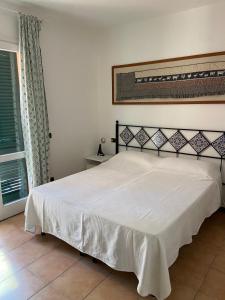 a bedroom with a bed with a white bedspread at Residence Le Solane in Marina di Campo +95 photos