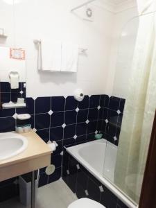 a bathroom with a sink and a toilet and a tub at Hotel Atlântica in São Martinho do Porto