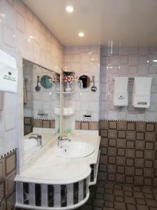 y baño con lavabo, bañera y toallas. en Alsafa Hotel, en Al Buraymī