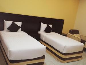 two beds sitting next to each other in a room at Alsafa Hotel in Al Buraymī