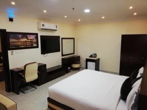 a hotel room with a bed and a flat screen tv at Alsafa Hotel in Al Buraymī
