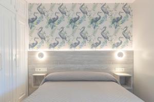 um quarto com uma cama e uma parede com papel de parede de pavão em Hotel Leal - La Sirena em Vilanova de Arousa