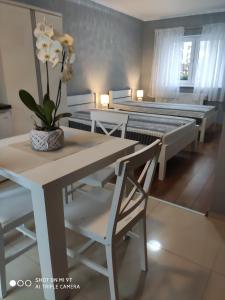 a dining room with two beds and a table and chairs at Apartamenty i Pokoje Biala Hortensja in Ustronie Morskie