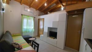 a small living room with a couch and a tv at Franceska apartmani in Cres