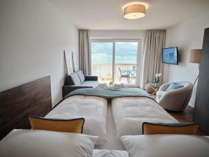 a bedroom with a large bed and a living room at SEE Moment Appartements ADULTS ONLY in St. Wolfgang