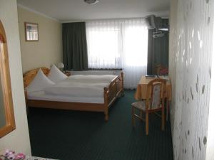 um quarto com uma cama, uma mesa e uma janela em Gasthaus und Pension Zum Biber em Steckby