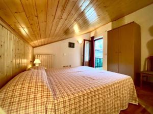 a bedroom with a large bed with a checkered blanket at Casa Ortensia in Pellizzano