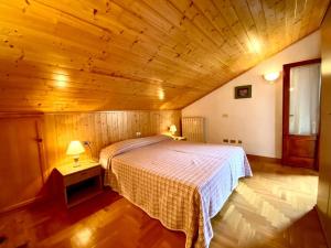 a bedroom with a bed and a wooden ceiling at Casa Ortensia in Pellizzano