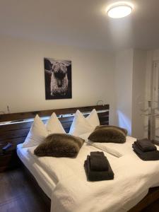 a large white bed with two brown pillows on it at Emelie Zermatt 4**** in Zermatt