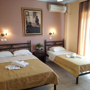 a hotel room with two beds and a picture on the wall at Xenia Palace luxury apartments in Nea Vrasna