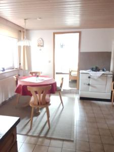 uma cozinha com mesa e cadeiras num quarto em Ferienwohnung Sander em Wendershausen