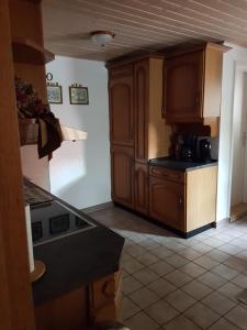 a kitchen with wooden cabinets and a black counter top at Ferienwohnung Sander in Wendershausen