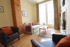 a living room with a couch and a chair at Old Town View - Picture Perfect! in Edinburgh