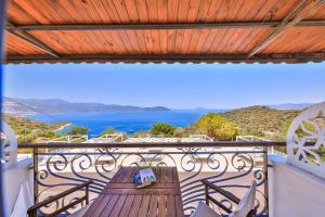 a wooden table on a balcony with a view of the ocean at Hamarat Otel in Kaş