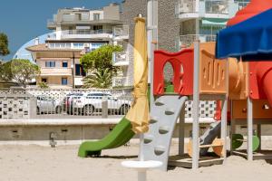 un parco giochi con scivolo nella sabbia di Appartamenti Lignano Sabbiadoro - Villa Ammiraglia a Lignano Sabbiadoro
