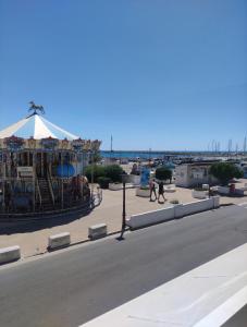 a street with a carnival ride and a tent at Abrivado in Saintes-Maries-de-la-Mer