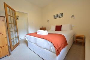 a bedroom with a bed with a orange blanket at Old Town View - Picture Perfect! in Edinburgh