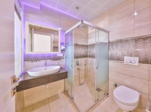 a bathroom with a toilet and a sink and a shower at Hamarat Otel in Kaş