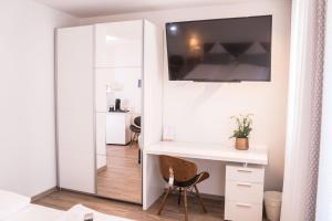 Zimmer mit einem weißen Schreibtisch und einem Spiegel in der Unterkunft CityApartements FN2-FN4 KLIMATISIERT in Friedrichshafen