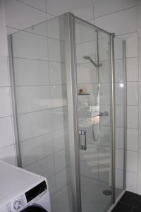 um chuveiro com uma porta de vidro na casa de banho em Haus Bootsmann em Krummhörn