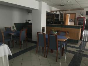 Garni G Hotel Žilina في زيلينا: غرفة طعام مع طاولات وكراسي وكاونتر