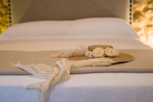 un sombrero en una cama con un vestido y rosas en CASA PACO - Casita con Encanto, en Medina Sidonia