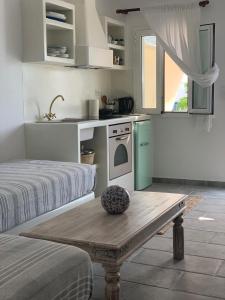 uma cozinha com uma mesa e uma cozinha com um fogão em Astrofegia guest house em Donousa