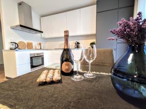 Sunshine apartment for 6 & Terrase & Free Parking في زيلينا: طاولة مع زجاجة من النبيذ وكأسين