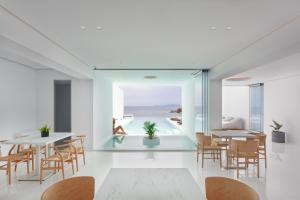 Infinity View Hotel Tinos في تينوس تاون: غرفة طعام مطلة على المحيط