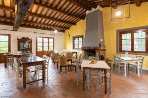 comedor con mesas y sillas y chimenea en Fattoria Sant'Andrea - Farm Stay, en San Gimignano