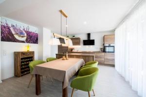 a dining room with a table and green chairs at Ruhe und Entspannung in Erpolzheim +12 photos