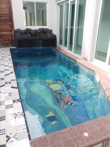 ein Pool mit Meerjungfrau, die in einem Haus schwimmt in der Unterkunft Origin hua hin poolvilla in Hua Hin