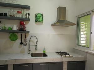 a kitchen with a sink and a stove at Villa Sonrisa in Las Terrenas