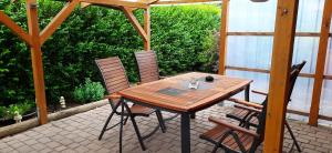 a wooden table and chairs on a patio at Ferienwohnung Baumann in Westoverledingen