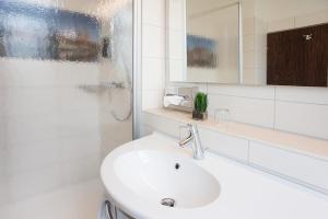 a white bathroom with a sink and a shower at LIHO - einfach Lübeck in Lübeck