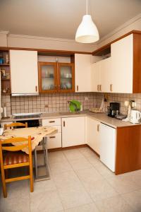 a kitchen with white cabinets and a wooden table at HOUSE WITH GARDEN Netflix in Néa Kerasiá